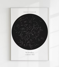 A personalized, hand-drawn star map print. The print features a detailed constellation map on a black background, showing the stars exactly as they appeared on a specific date and location. This is an ideal personalized anniversary gift, unique wedding present, or romantic engagement keepsake for home wall art.