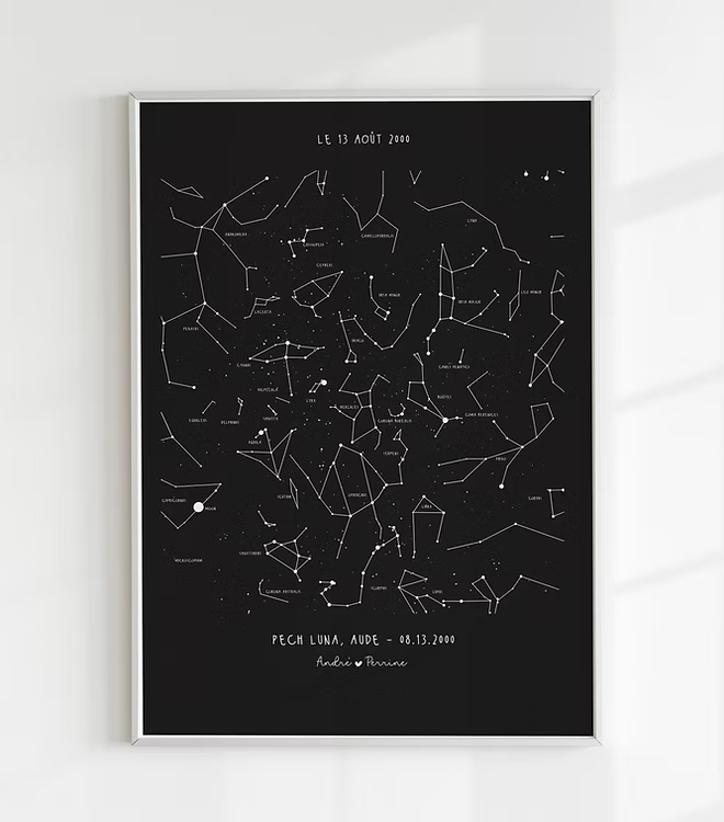 A personalized, hand-drawn star map print. The print features a detailed constellation map on a black background, showing the stars exactly as they appeared on a specific date and location. This is an ideal personalized anniversary gift, unique wedding present, or romantic engagement keepsake for home wall art.