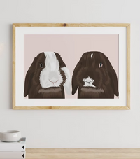 Framed CostanzaToniniDesign artwork of two brown and white rabbits on pale pink background