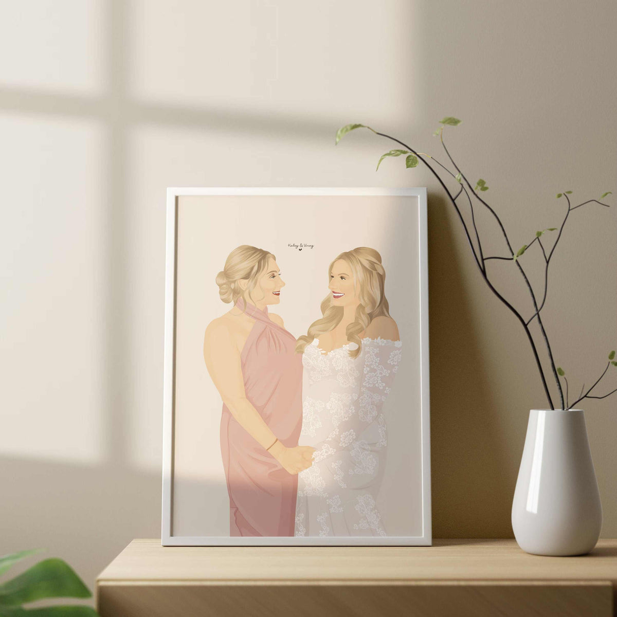 A personalized portrait as a gift for your bridesmaid. A framed illustration of two women in wedding attire. The woman on the left is wearing a pink dress and the woman on the right is wearing a white lace dress. The text "Truly & King" is written in the top right corner of the illustration.