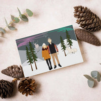 A custom Christmas card featuring a personalized family portrait for Christmas cards, showcasing a hand-drawn illustration of a couple standing hand-in-hand in a snowy winter forest with pine trees, reindeer, and a northern lights sky. Perfect holiday gift custom holiday greeting card design.