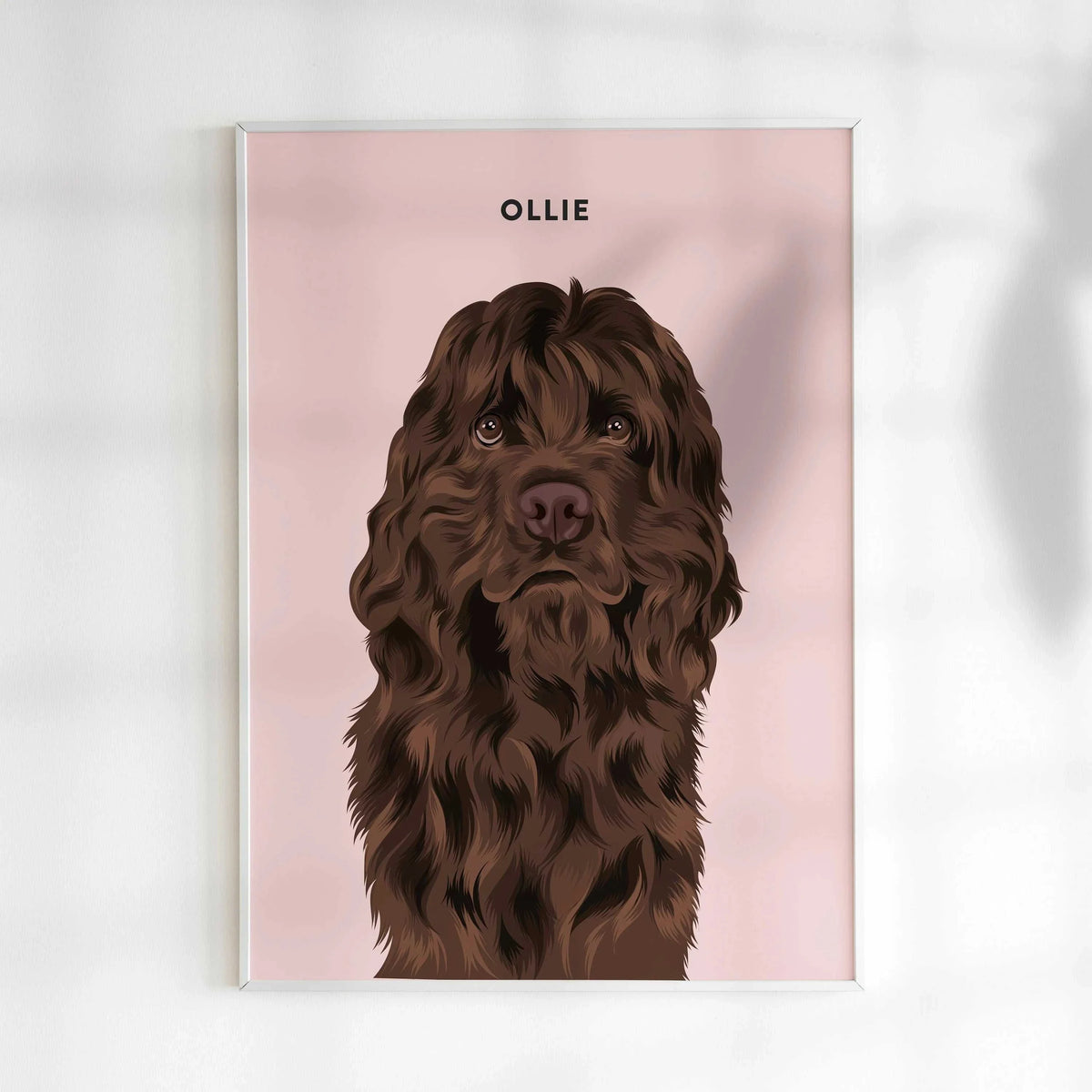 A custom pet portrait illustration in a realistic style, featuring a Chocolate Cocker Spaniel or long-haired brown dog with wavy fur and soulful eyes. The background is a solid blush pink, with the dog's name "OLLIE" written in bold black text above. This unique custom dog portrait is an ideal Cocker Spaniel gift, dog memorial art, or personalized wall print for modern pet owners.