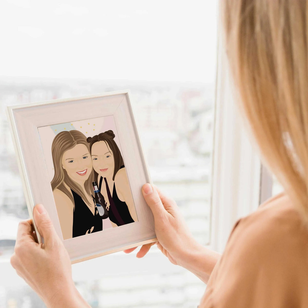 A woman holding a Personalized best friend portrait from photo in a light wood frame, featuring a hand-drawn digital illustration of two women laughing, holding a cocktails, with an aesthetic abstract background, perfect for roommate apartment decor.