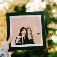 Hand-drawn custom best friend portrait of two women enjoying cocktails, featured in a sleek black frame. This personalized illustration is a touching gift for a best friend or a unique present for a friend who has everything, created from separate photos to capture a realistic likeness for a birthday or bachelorette party.