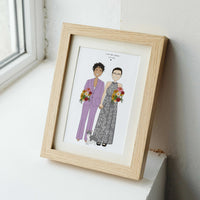 Personalized LGBTQ+ wedding portrait illustration of two brides and their cat, showcased in a light natural wood frame resting on a white window sill.